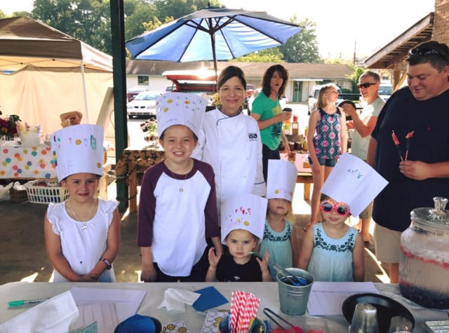 A group of young people standing in front of a table.