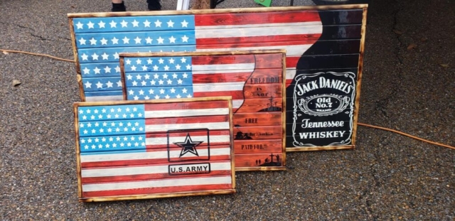 Three wooden American flags next to a Jack Daniels sign.